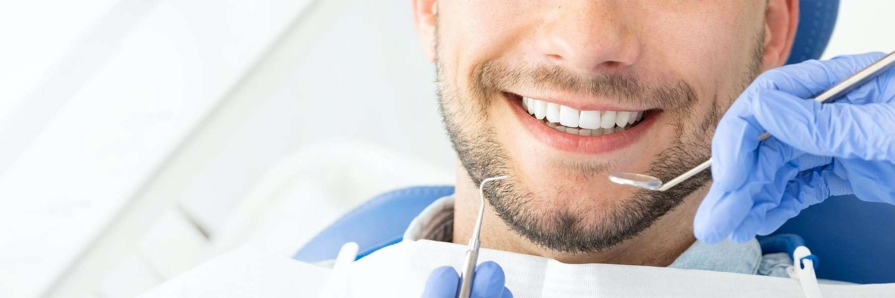 A smiling man getting a dental exam | Vienna dentist