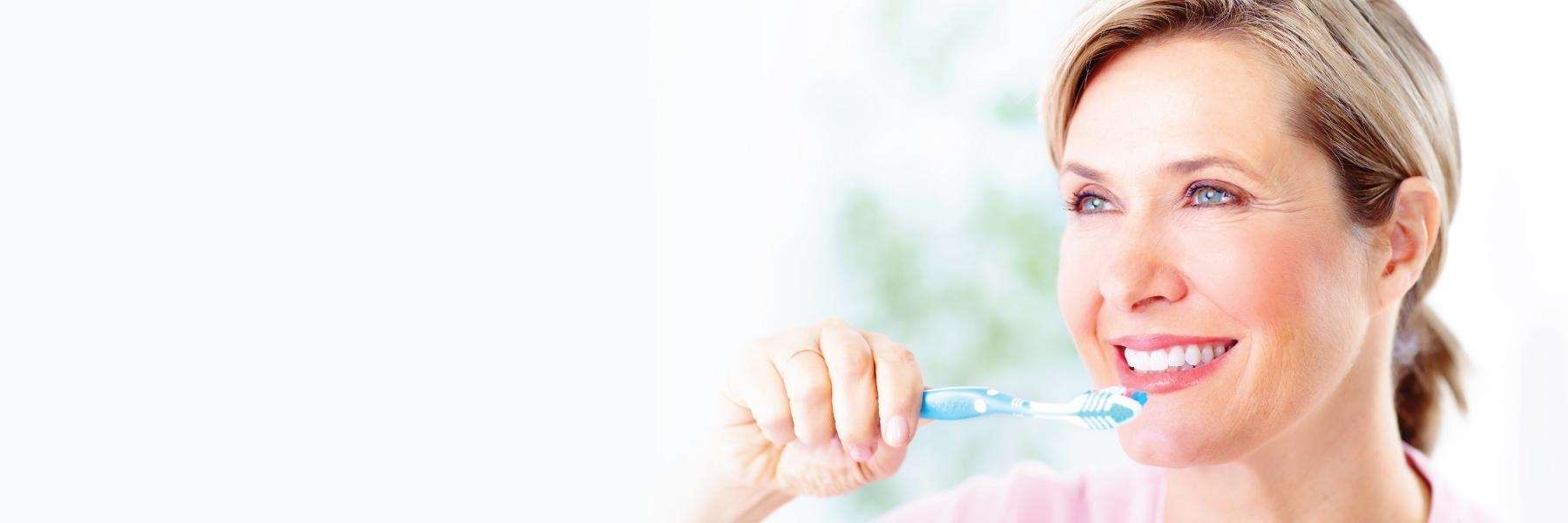 A woman brushing her teeth outside