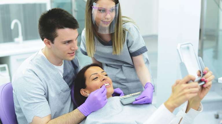 A woman choosing her desired tooth shade