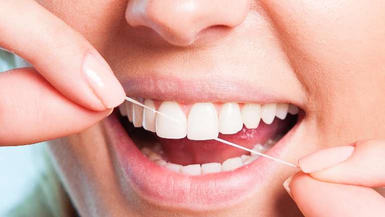 A woman flossing | dental hygiene Vienna