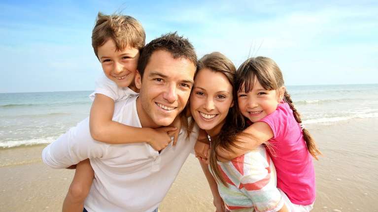 A smiling family on the beach | dental exam Vienna VA