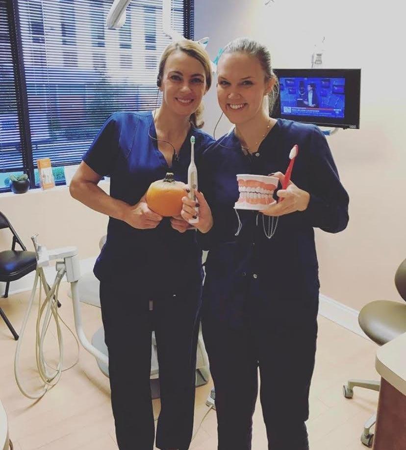 Team members smiling holding dental tools